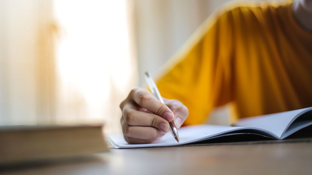 Person writing on a laptop with an open document